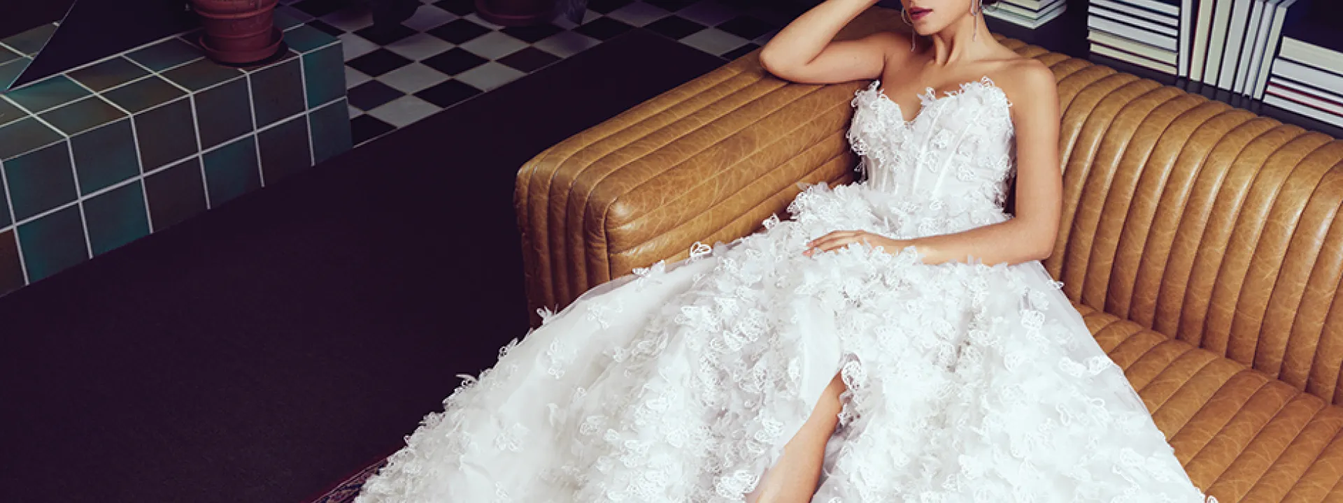 Bride lounging in library in butterfly applique Luly Yang “Butterfly Me to the Moon” gown.